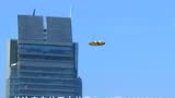 摩天大楼旁旋转的彩色UFO的图片
